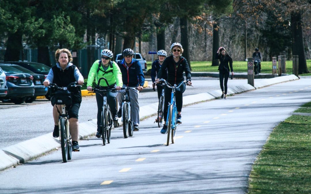 5 people cycling on a path